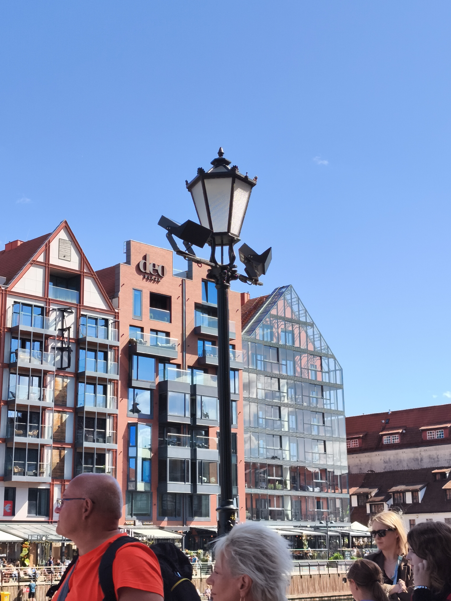 Ornate streetlamp against modern Gdańsk skyline