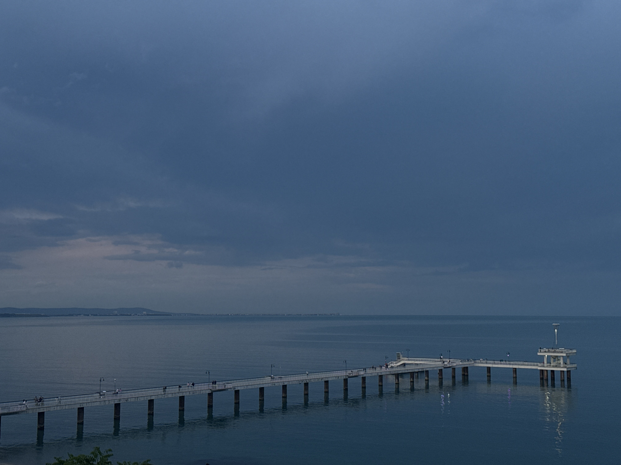 Evening strollers gather at Burgas Bridge pier during twilight