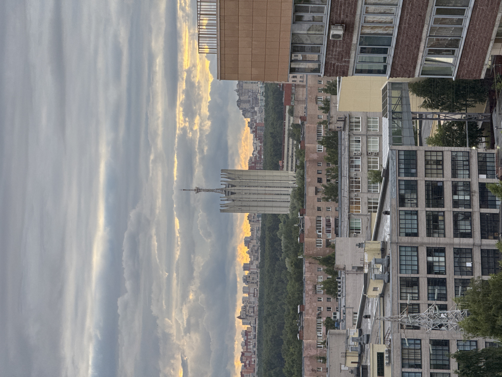 City skyline at sunset, dominated by a jagged-topped tower