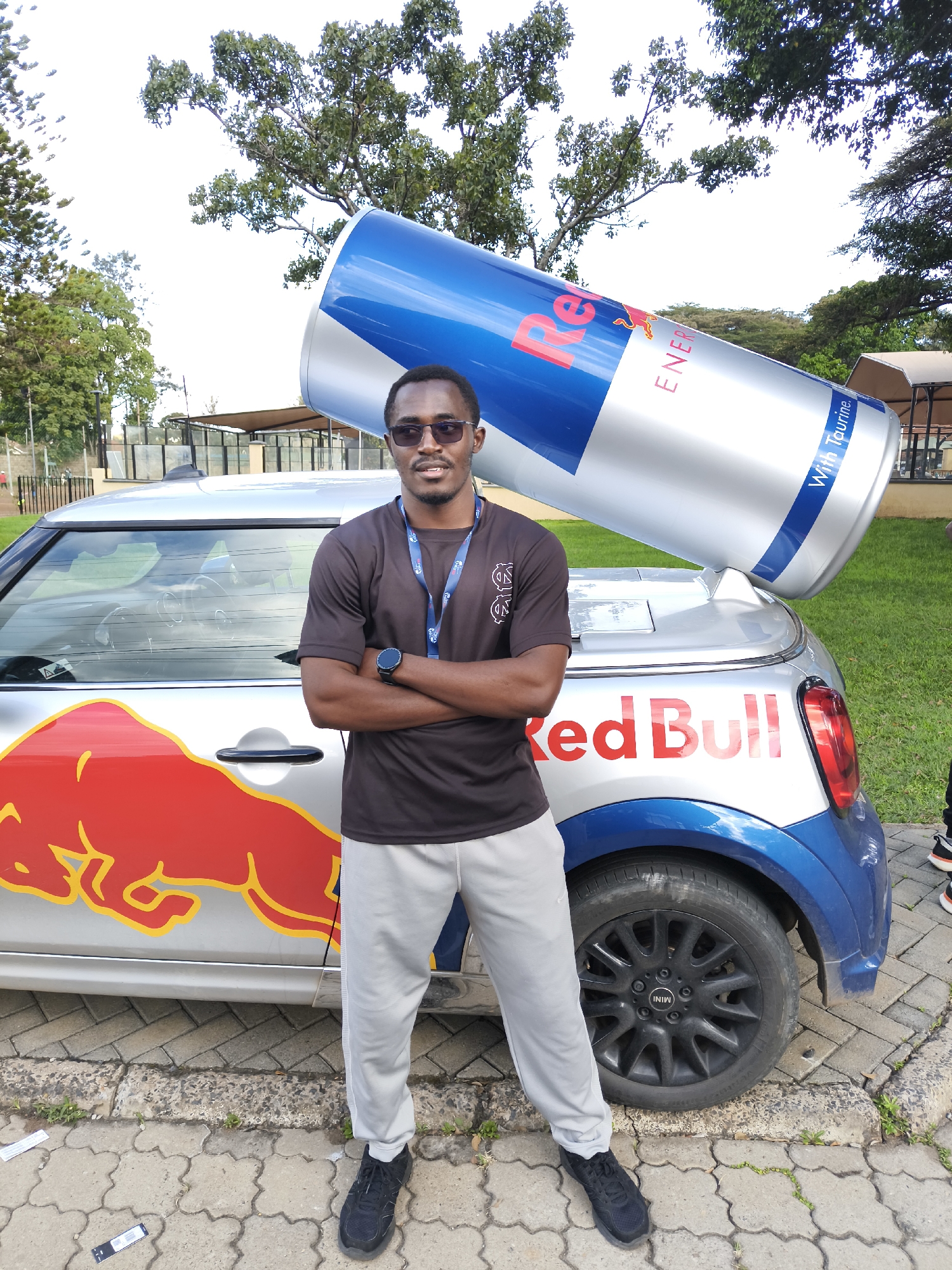 Man poses with Red Bull-branded Mini Cooper in Nairobi