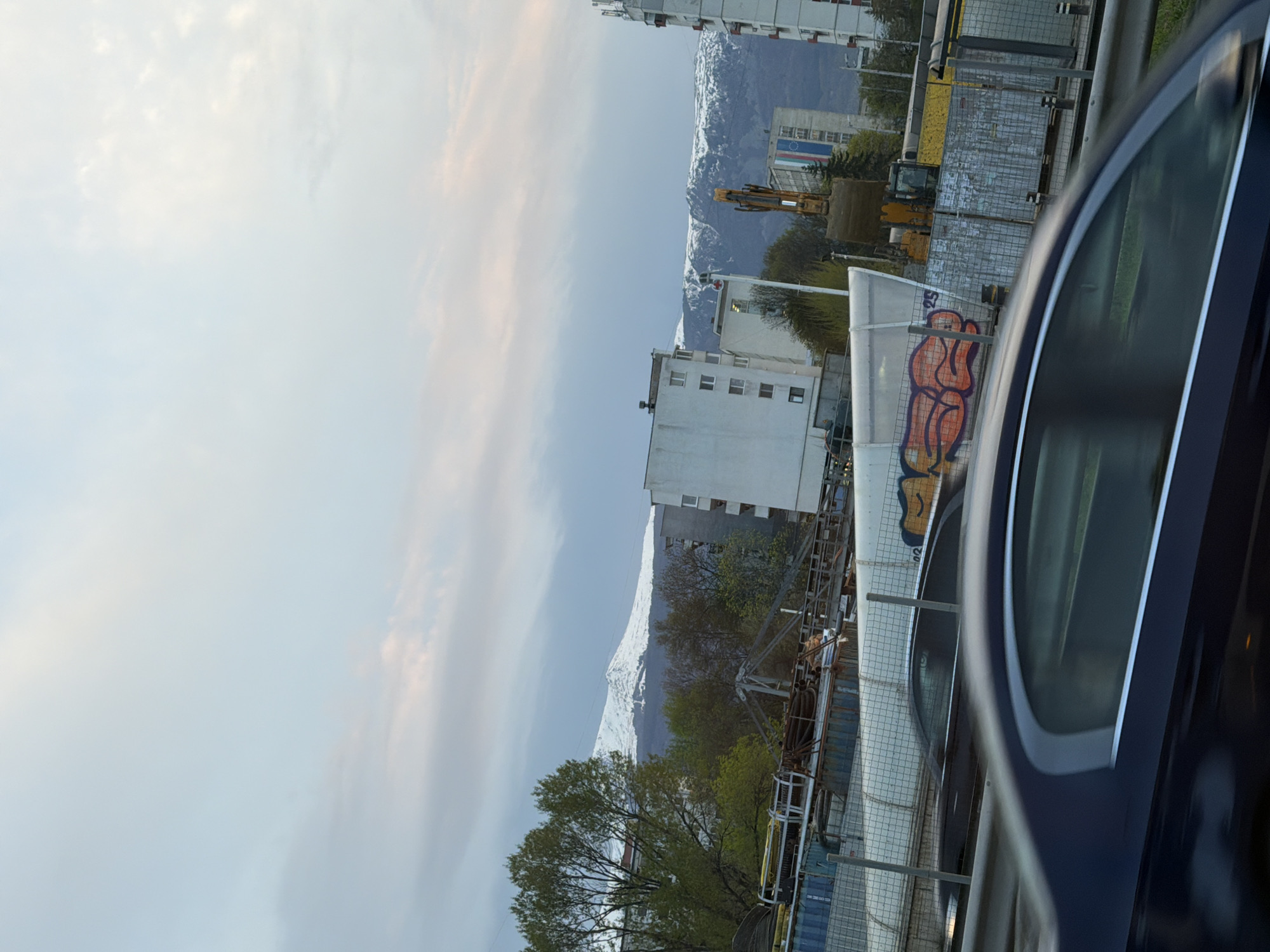 Evening urban street scene with snow-capped mountains observed