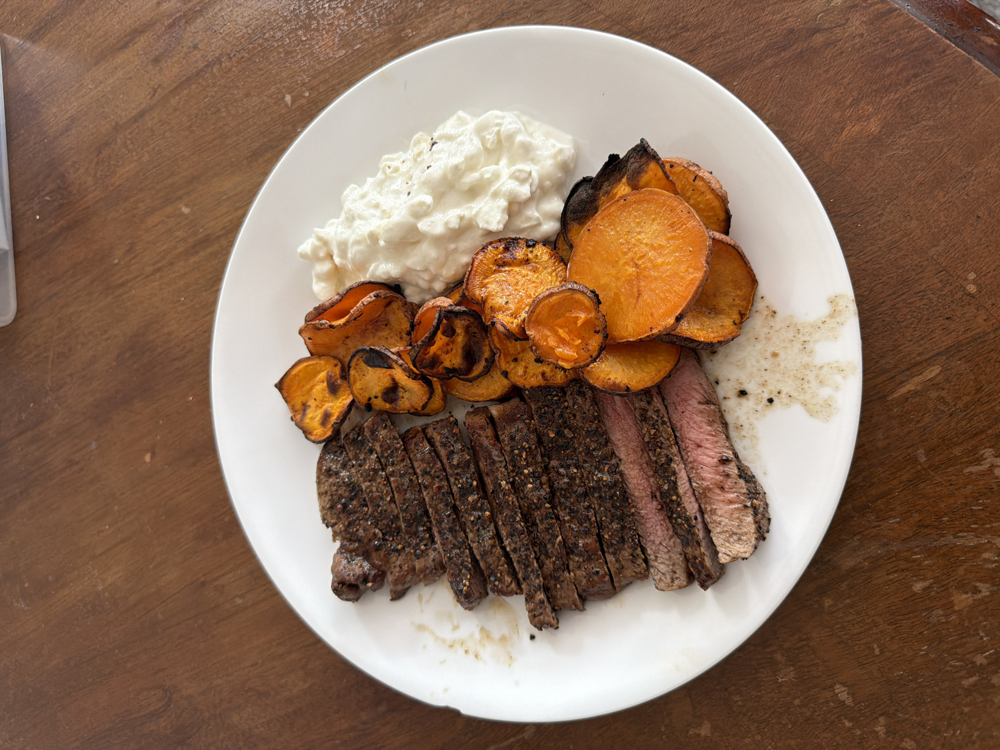 Steak cooked and plated with sweet potato and cottage cheese