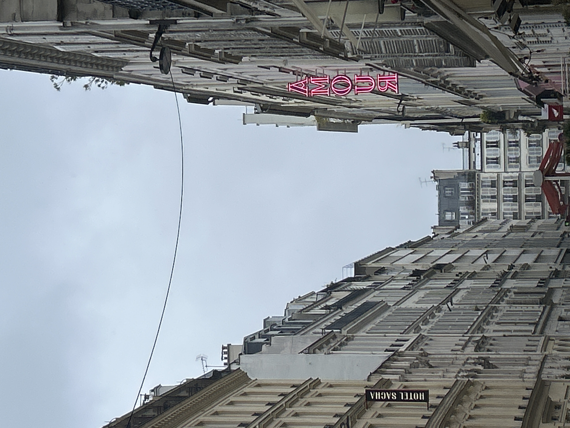 Paris street scenes show neon signage, shopfronts near afternoon