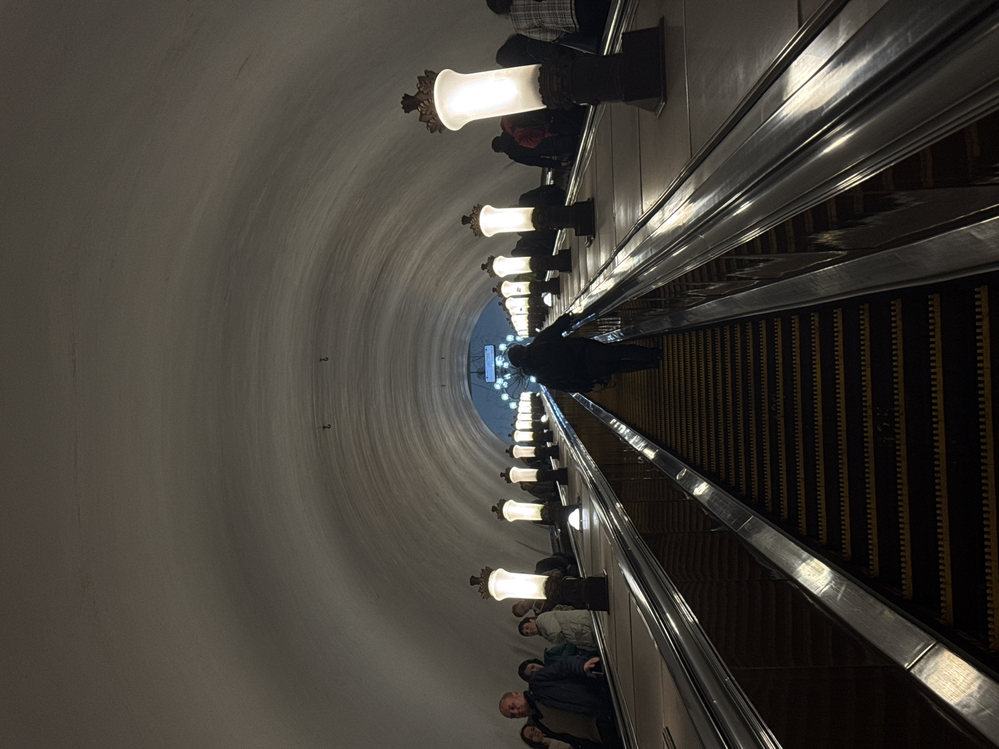 Moscow metro station captured with escalator passengers, star mosaic