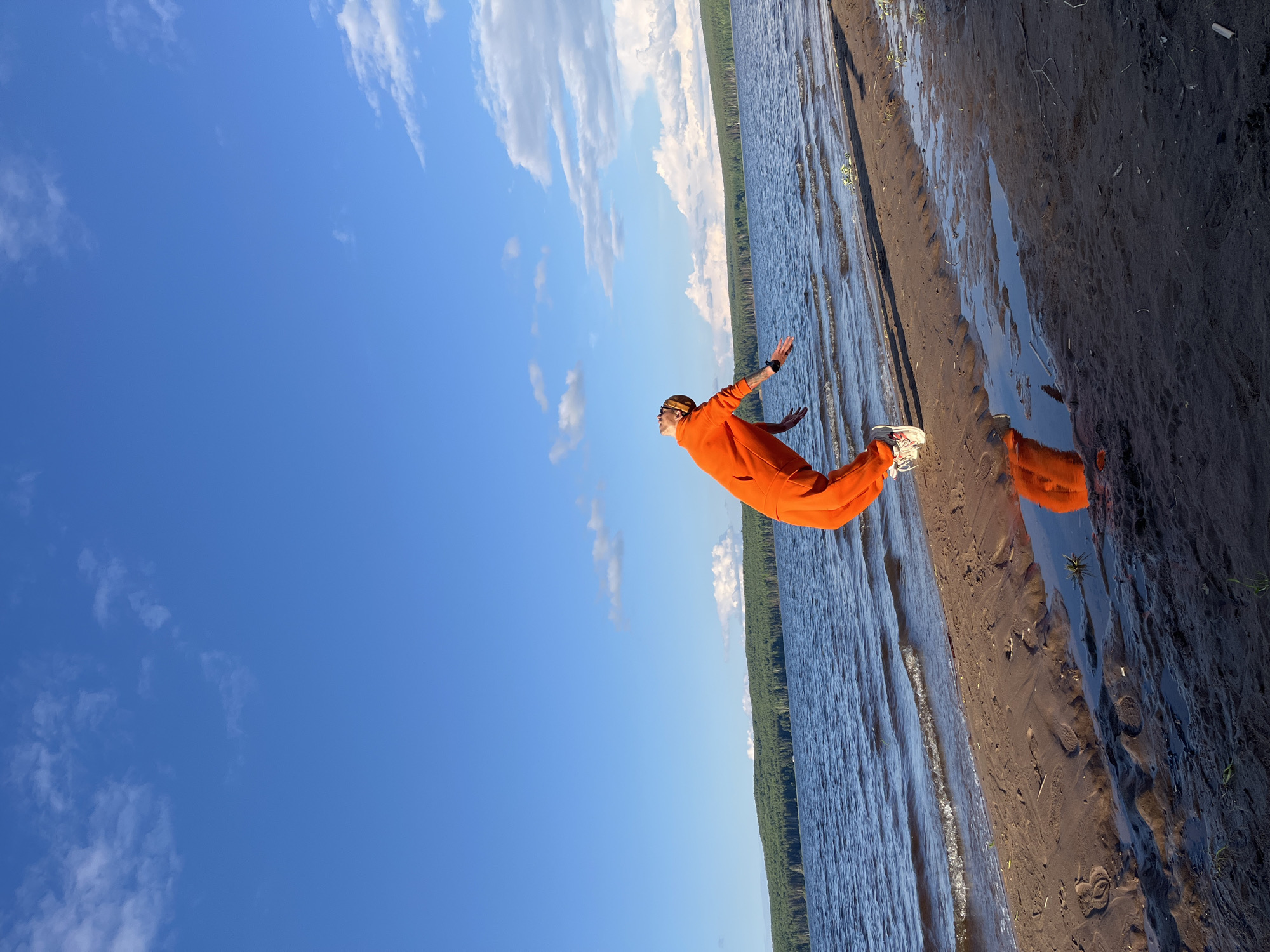 Person jumps on shore creating water reflection in Chaikovsky