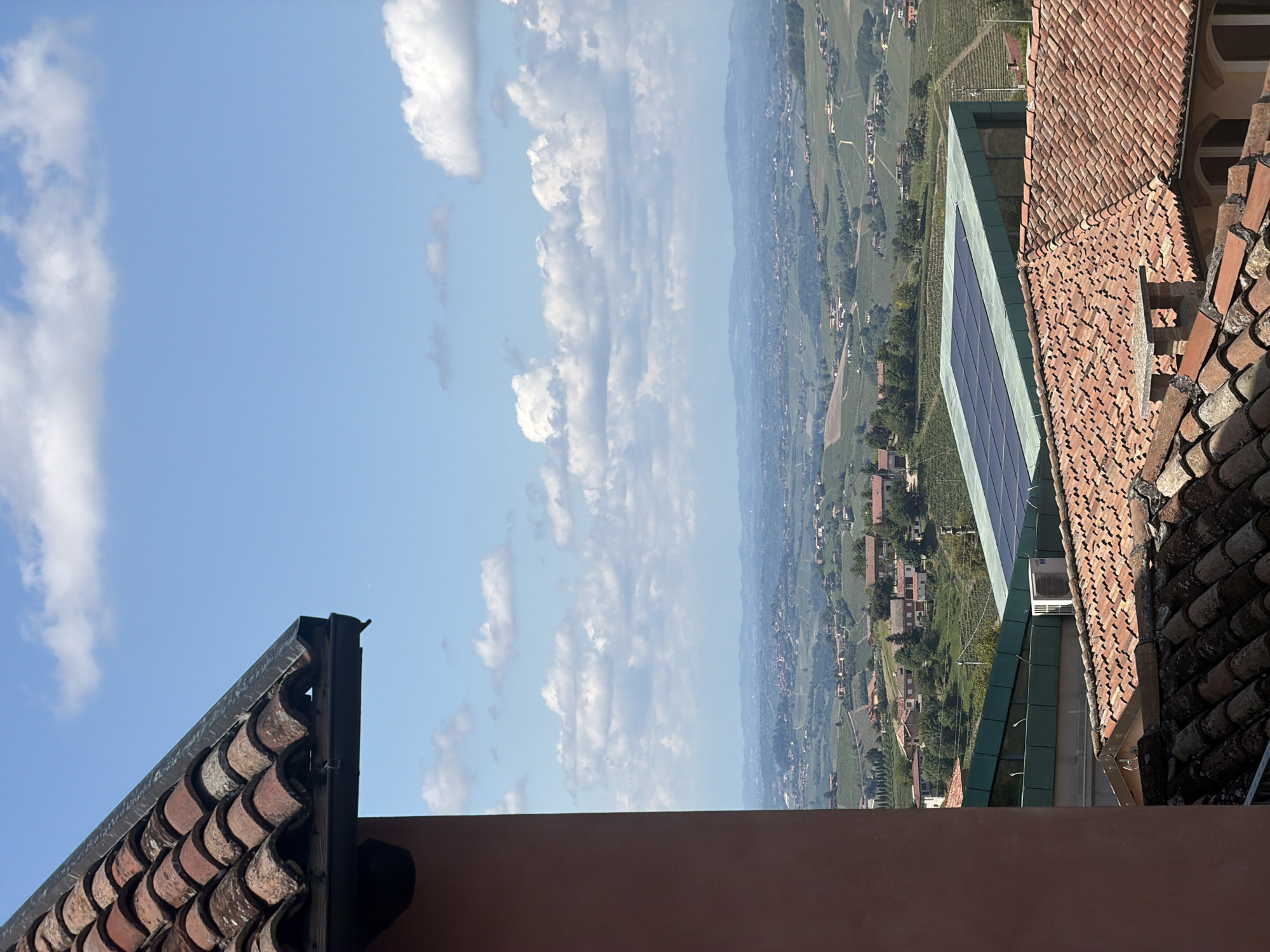 Elevated view captures Castiglione Tinella rooftops under blue sky
