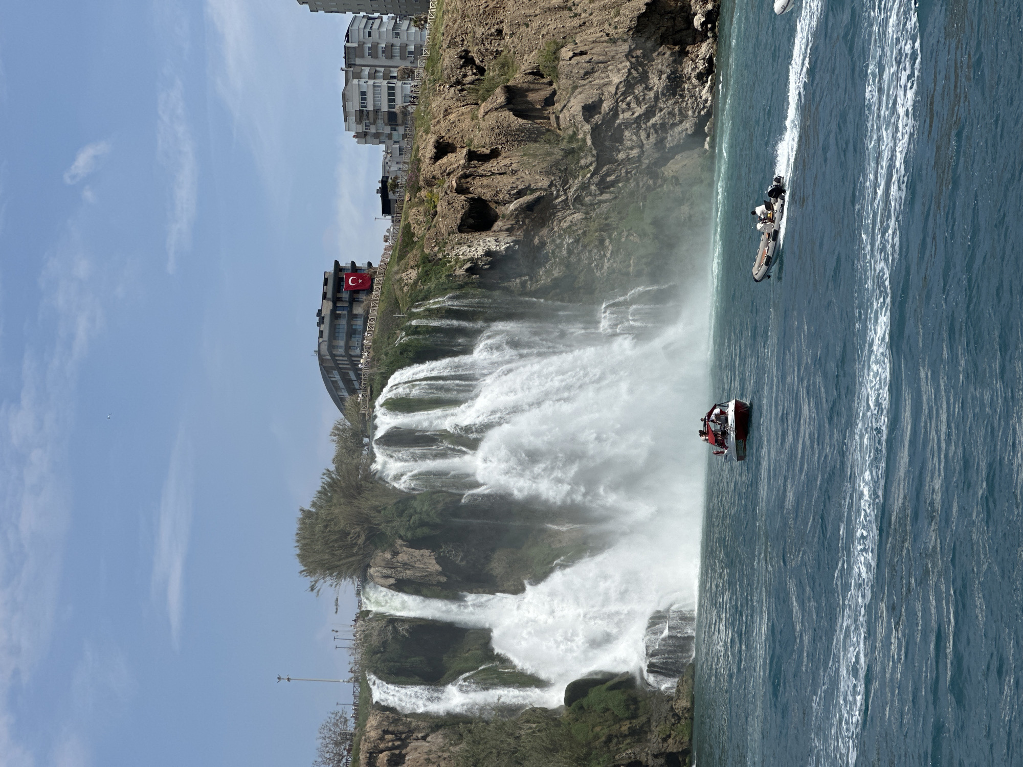 Tourist documents Düden Waterfall cascading into Mediterranean from boat