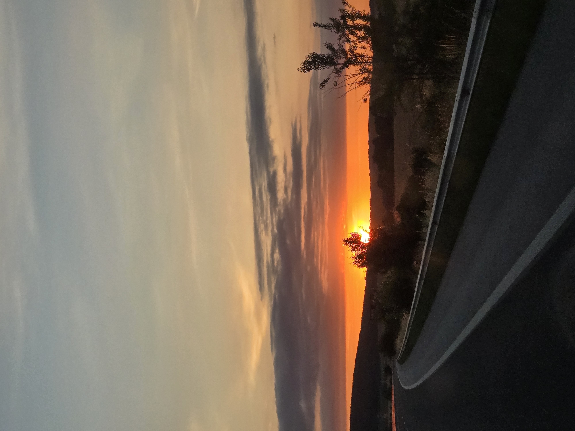 Driving into a rural sunset along an open highway