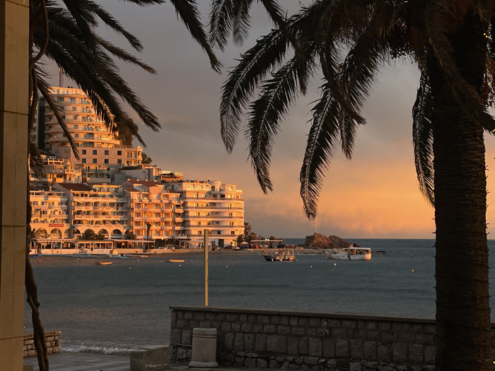 Tourist documents sunset evening along Montenegro's Budva coast