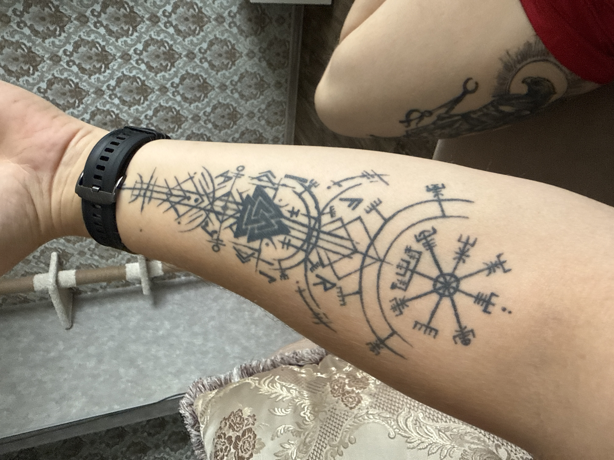Esoteric tattoo work featuring runes, geometry, and Egyptian mythology