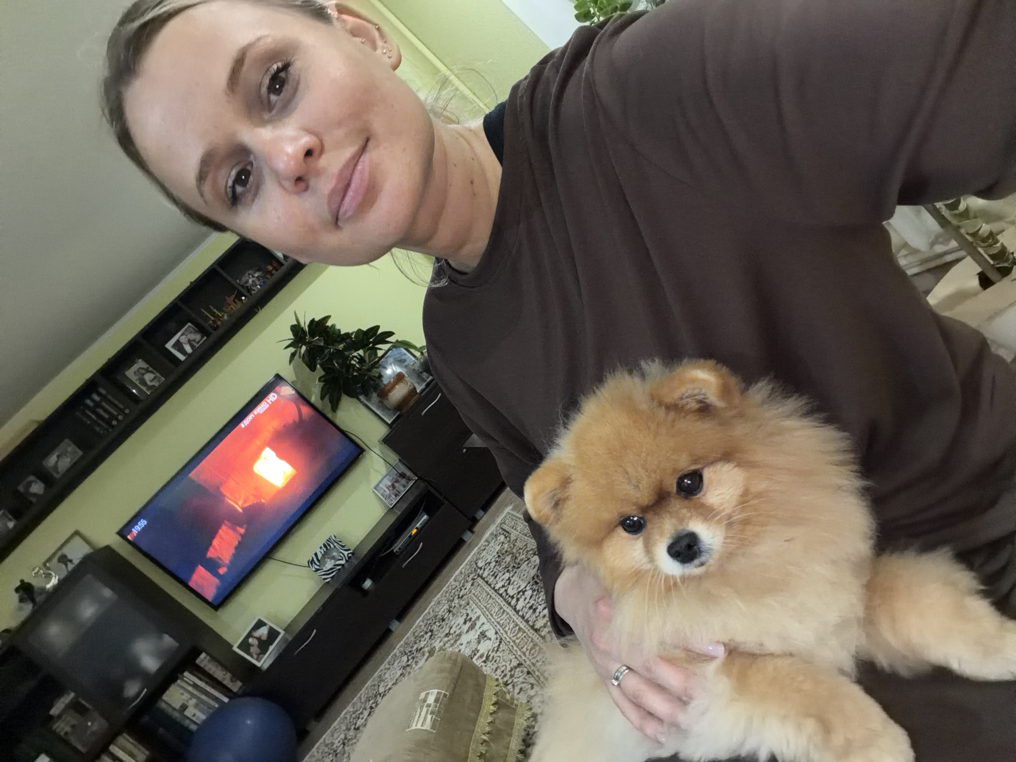 Woman holds Pomeranian dog at home in Sarapul, Russia