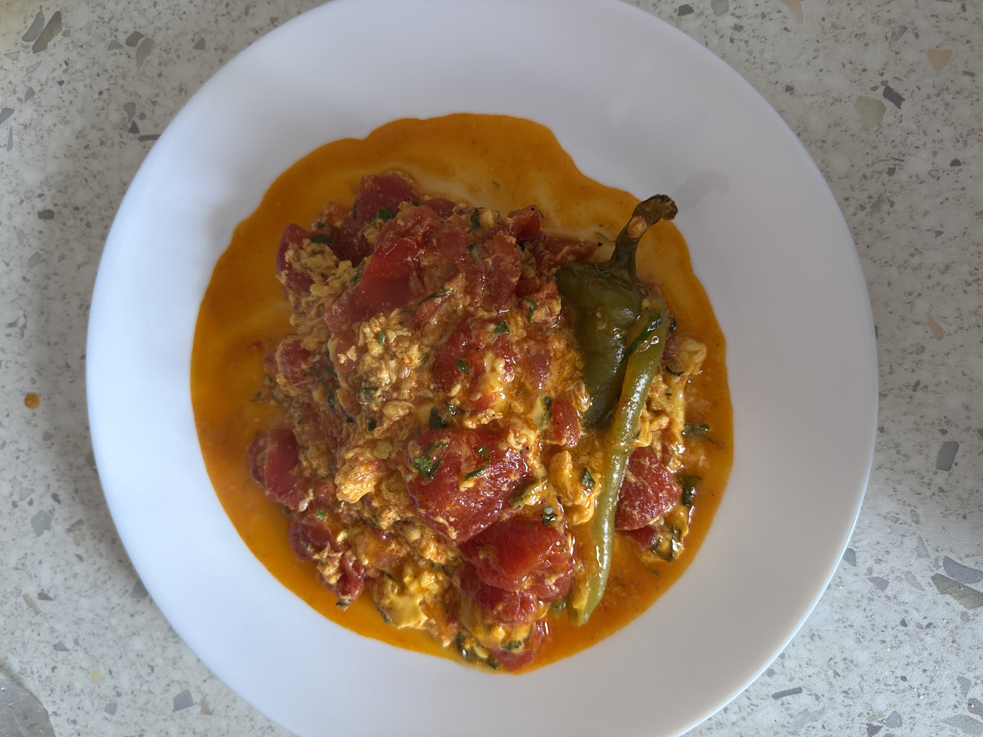Scrambled eggs with tomatoes and peppers, cooked and plated in Milan