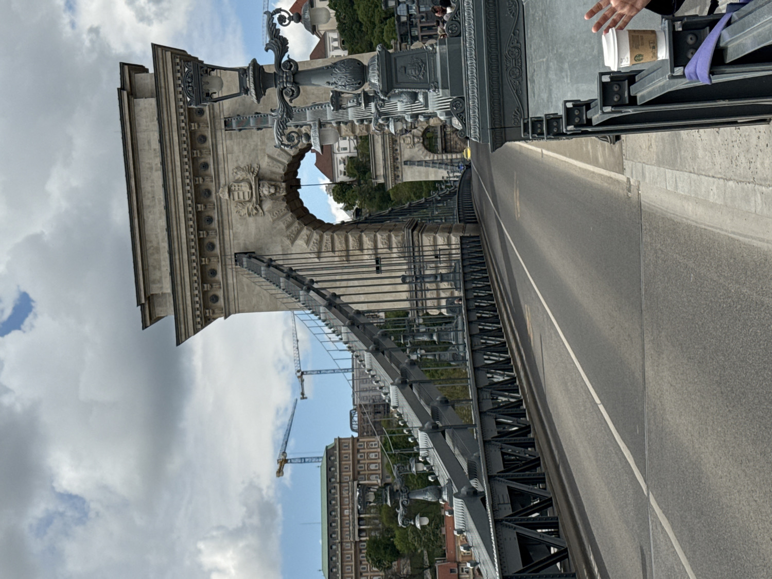Tourist documents Chain Bridge and Budapest landmarks under cloudy skies