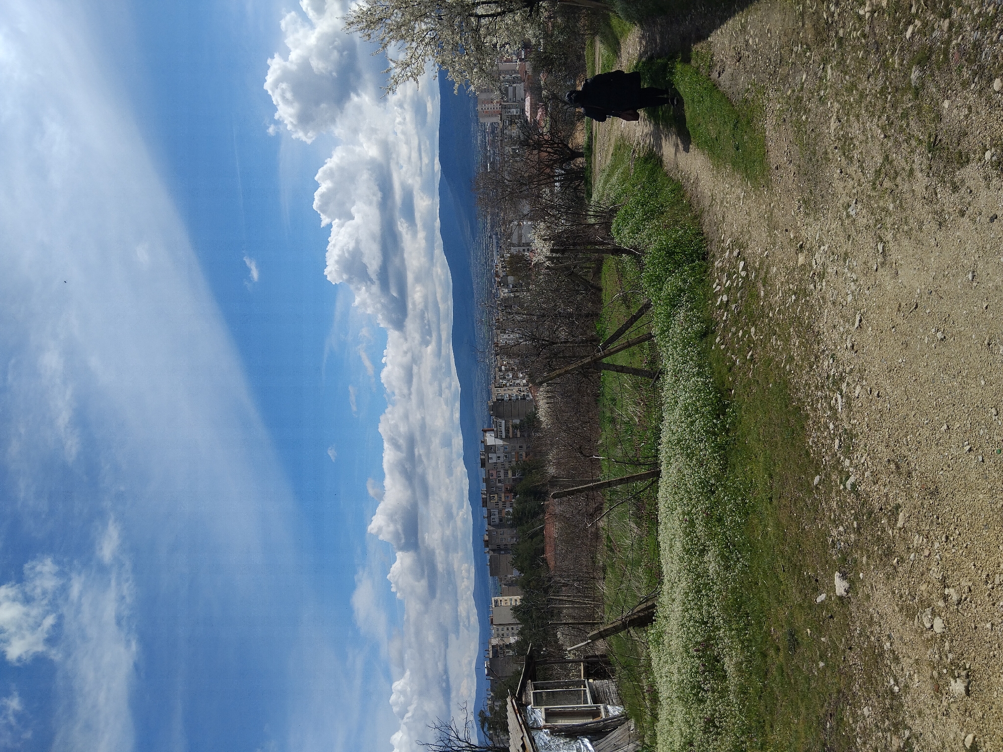 Person walks dirt path toward Kazanlak cityscape, Bulgaria