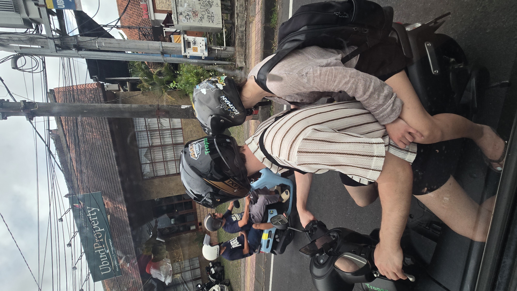 Early morning street activity documented around Balinese statue in Ubud