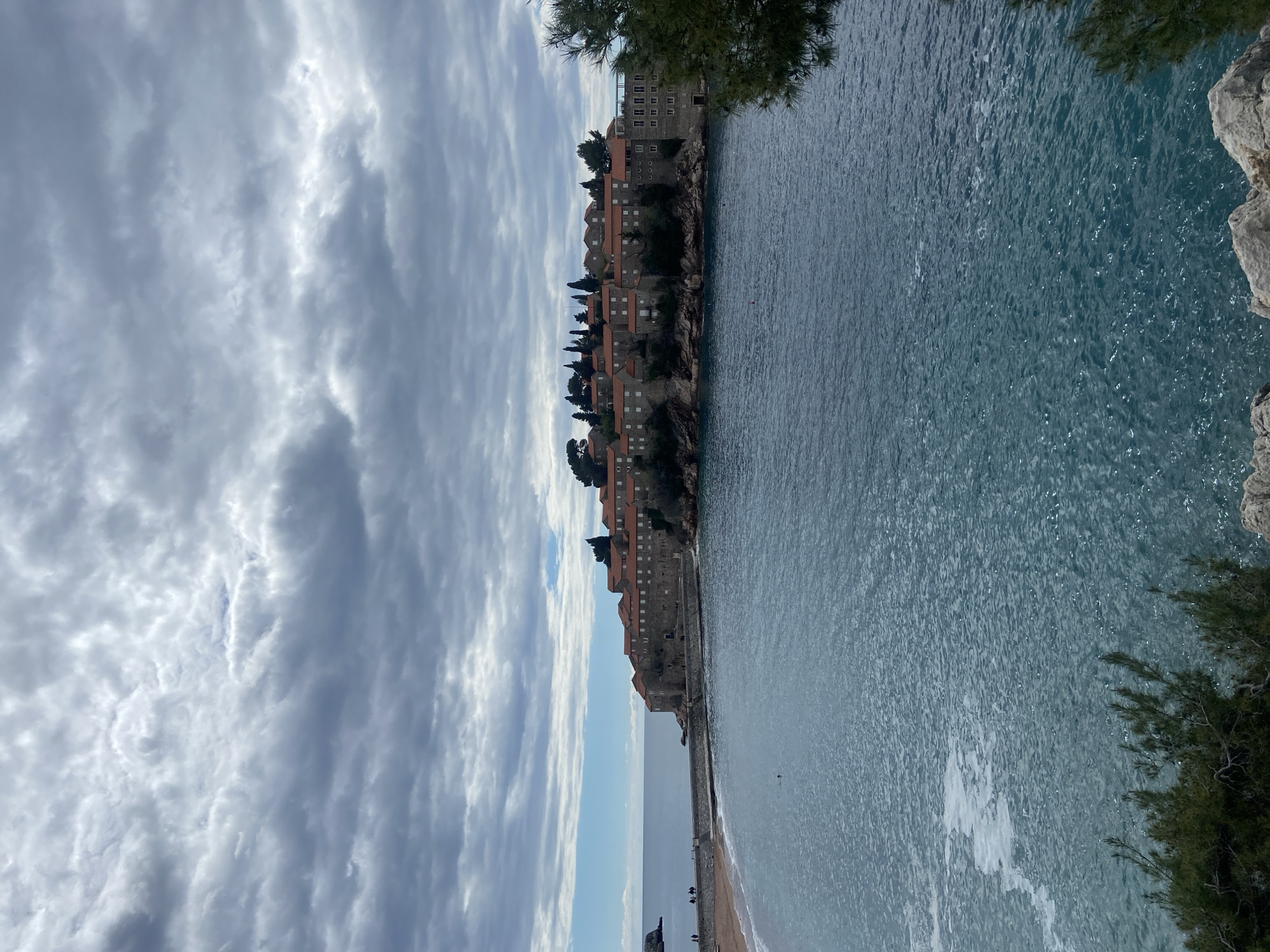 Tourist explores Montenegro's Sveti Stefan resort with pet dog