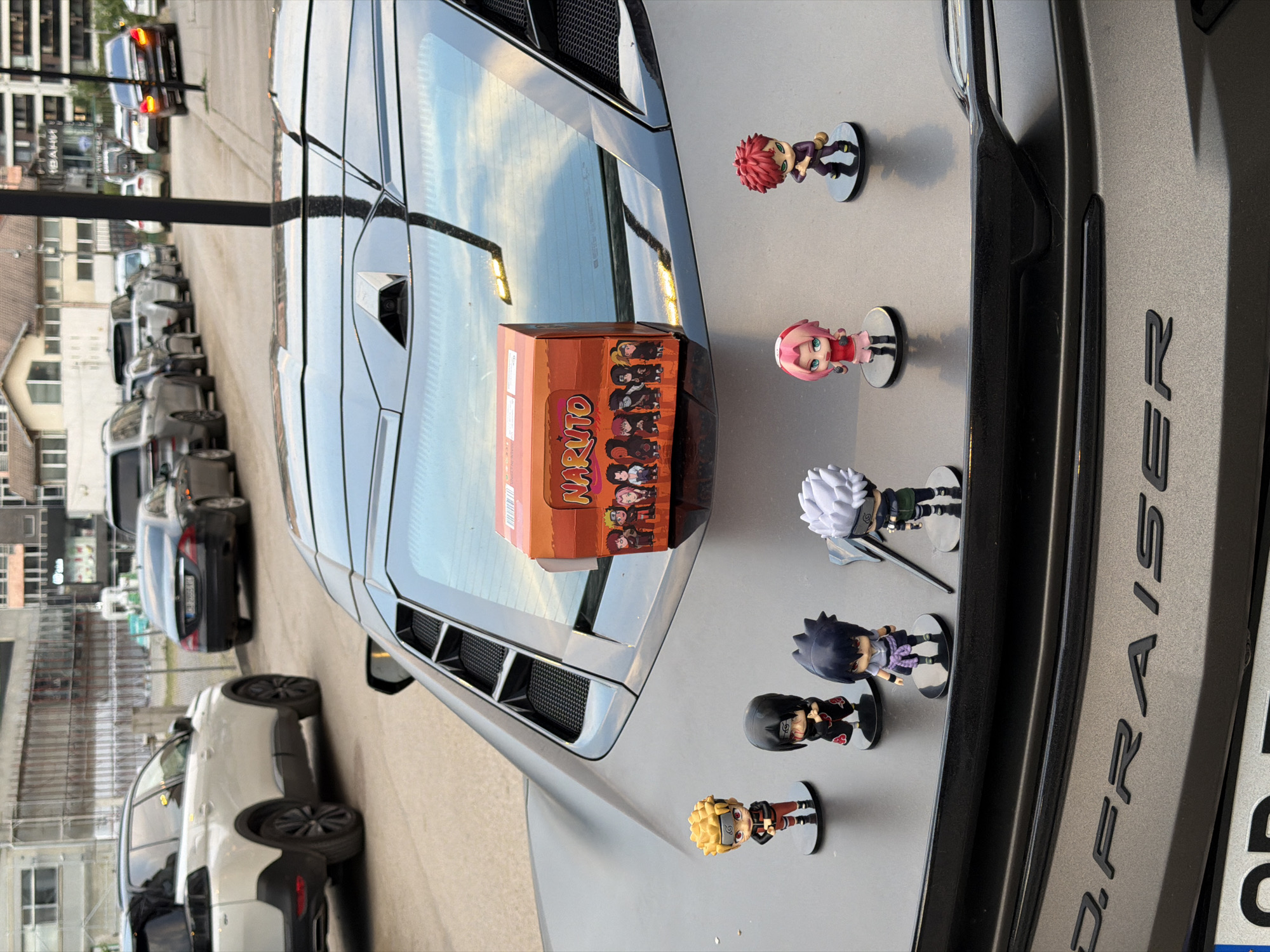 Naruto figurines displayed on a matte sports car in Sofia