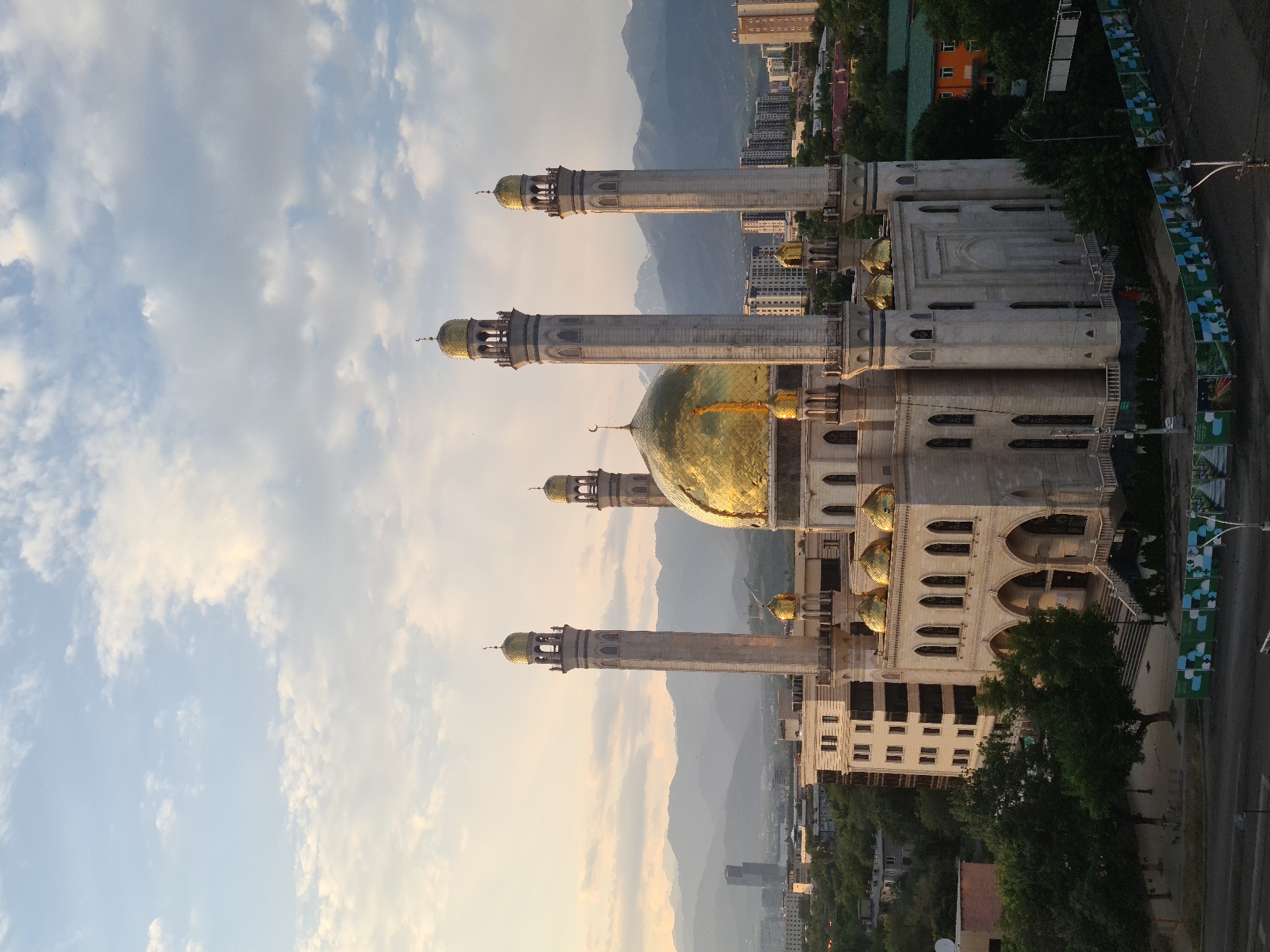 Almaty at sunset: mosque and skyline under golden skies