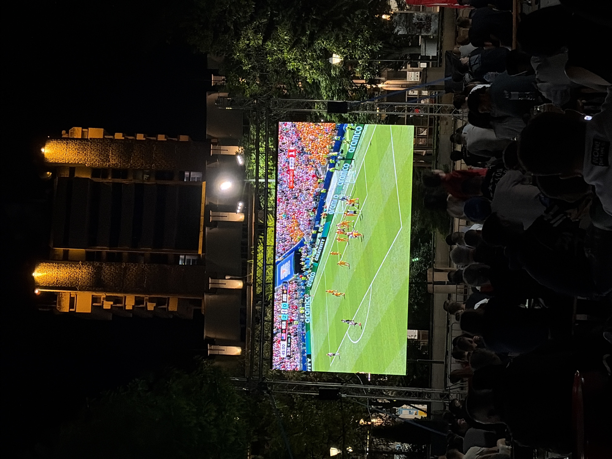 Outdoor soccer screening and a crescent moon through stormy clouds