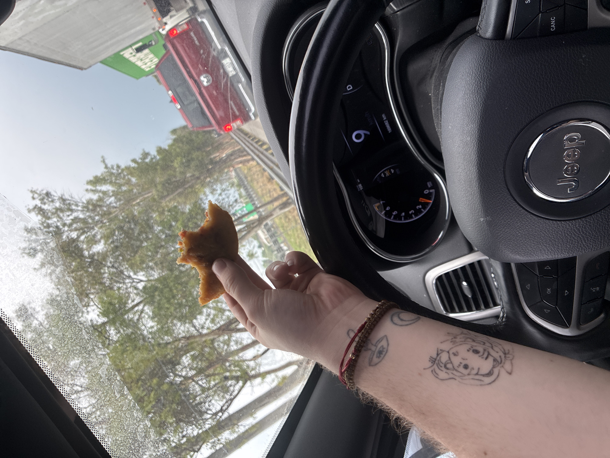 Person eats pastry in slow-moving Jeep in Tepotzotlán