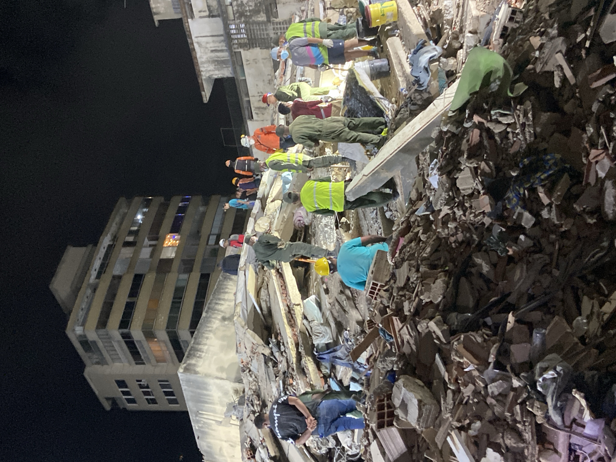 Rescue workers dig through collapsed building rubble in Caracas