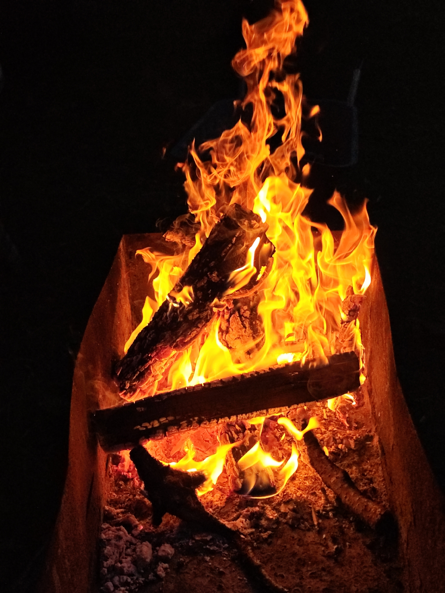 Evening bonfire burns in metal brazier in Парэчча, Belarus