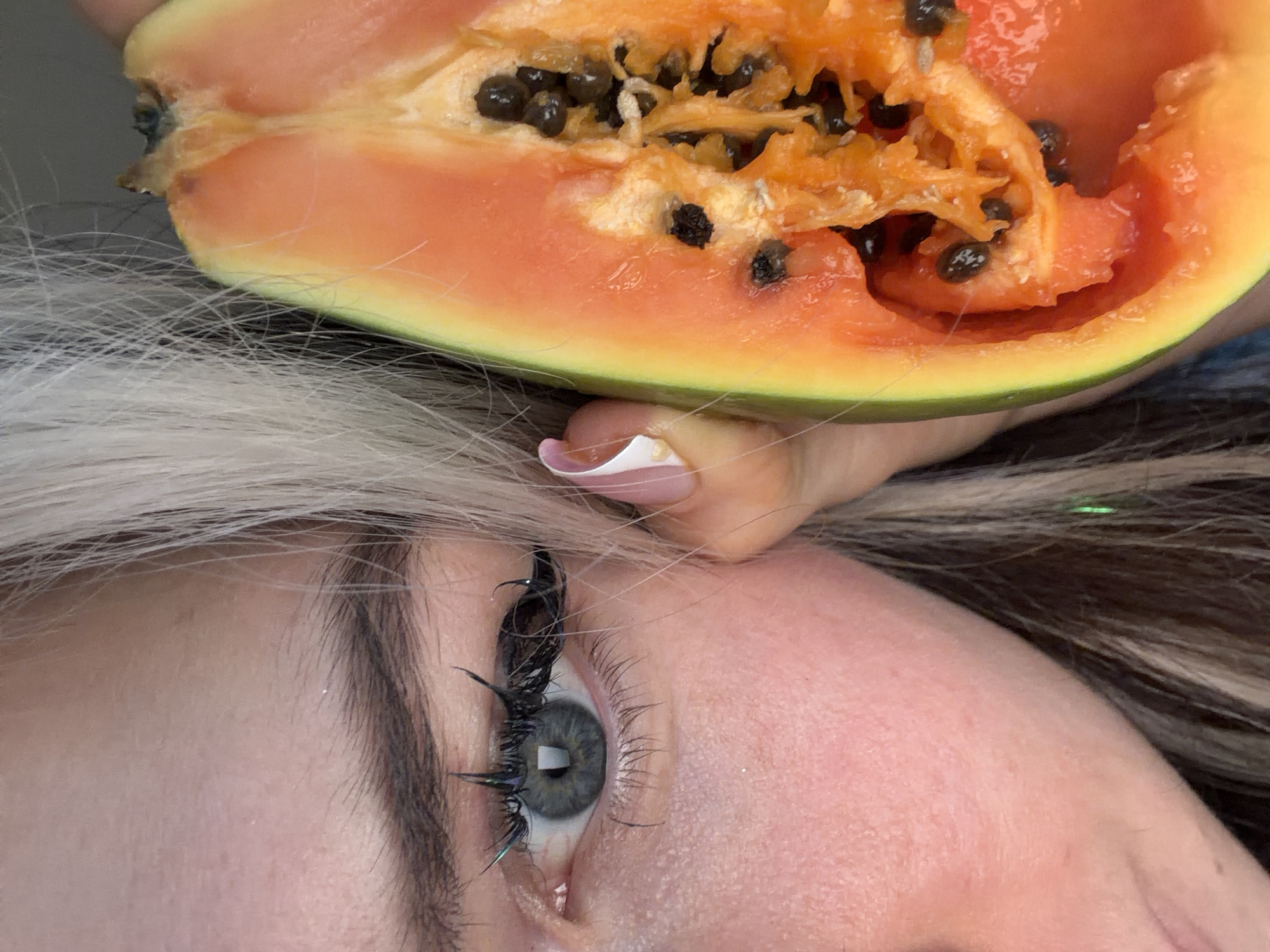 Woman photographed with halved papaya fruit in Budva, Montenegro