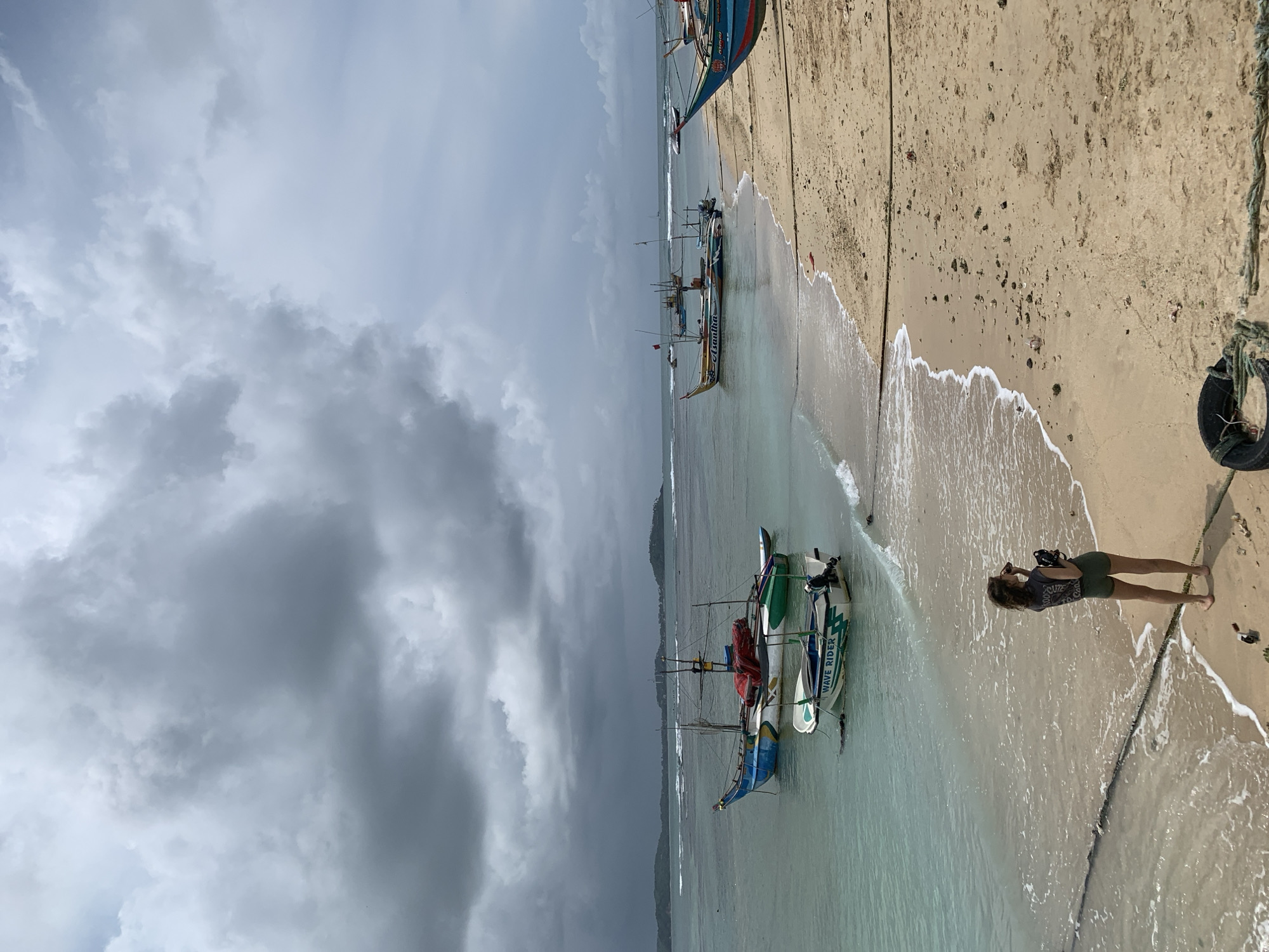 Woman walks beaches amid fishing boats in southern Sri Lanka