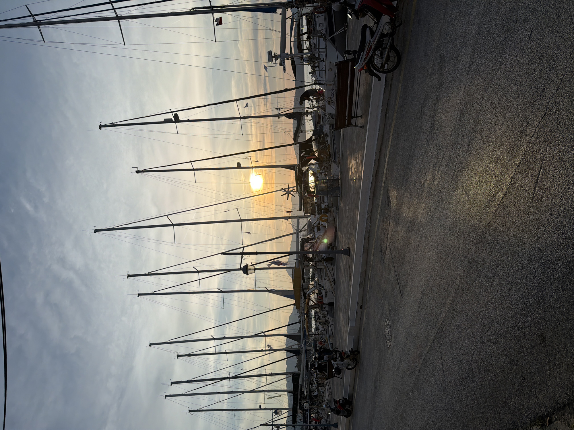 Golden sunset illuminates sailboat marina in Poros, Greece