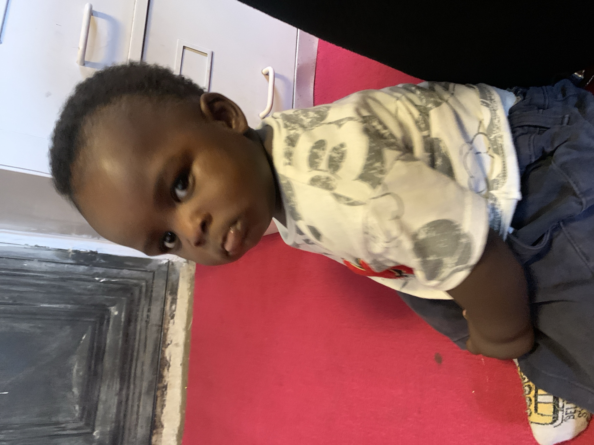 Home office hangout with a toddler, bookshelves, and TCHAD memorabilia