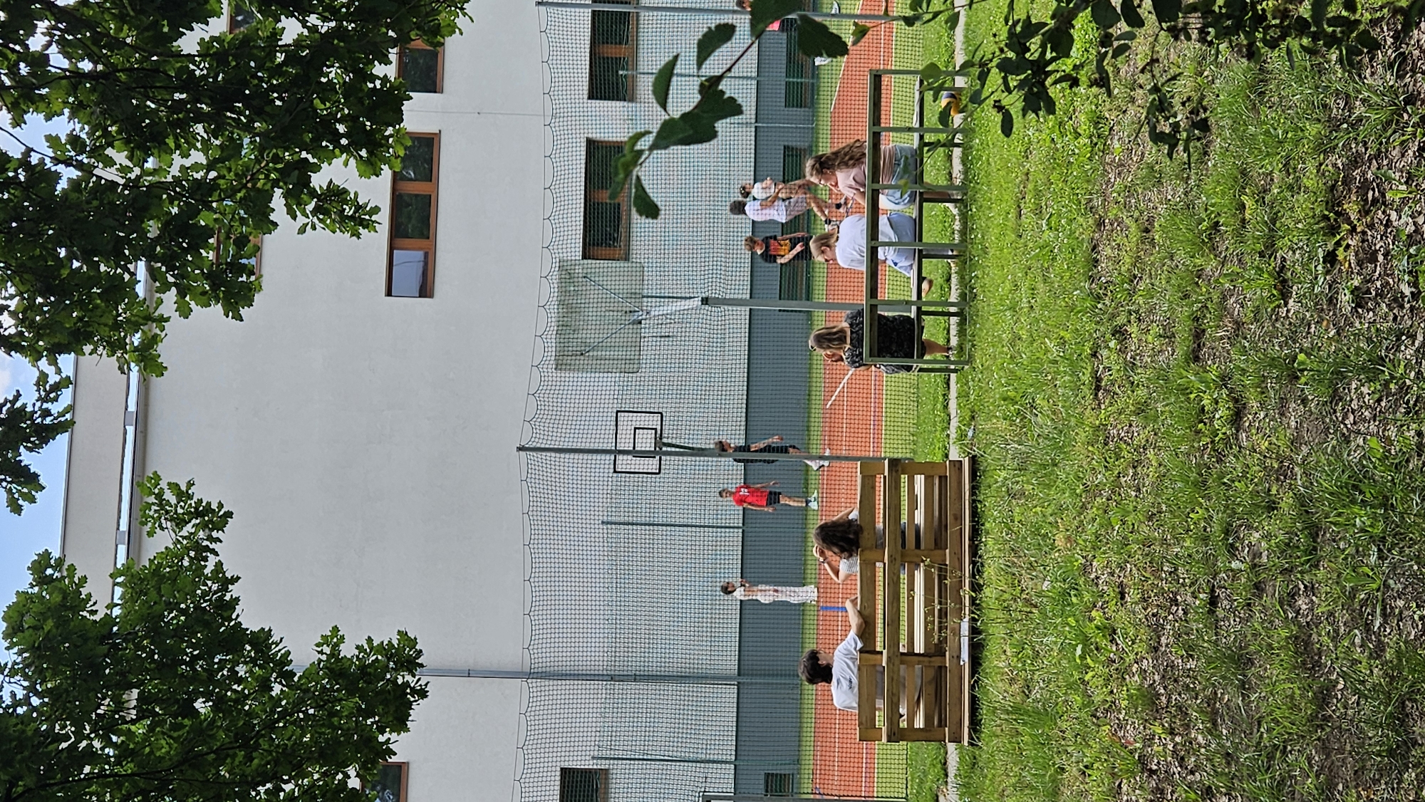 Sports court, blooming lilies, and building facades in Prešov