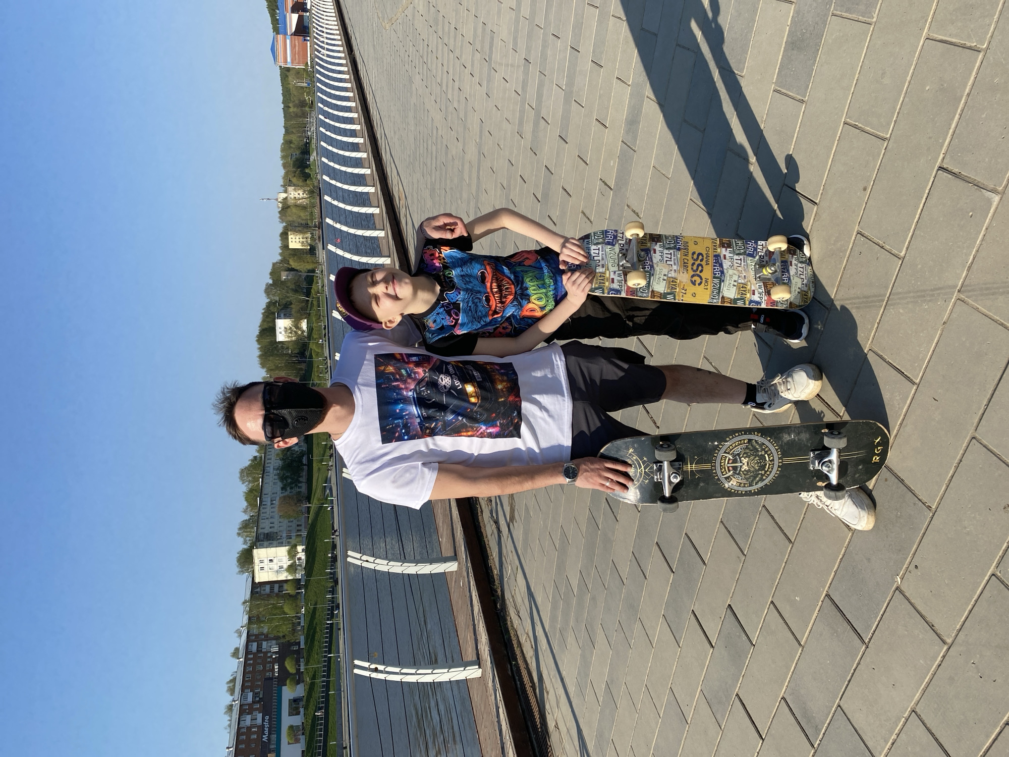 Father and son skateboarding by waterfront in Votkinsk