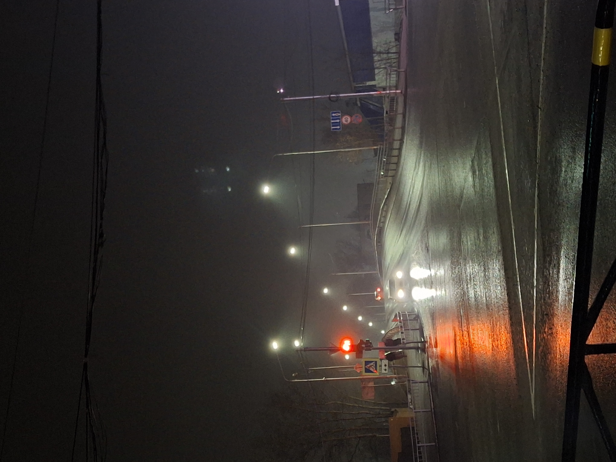 Woman photographs herself on foggy night streets in Chaikovsky