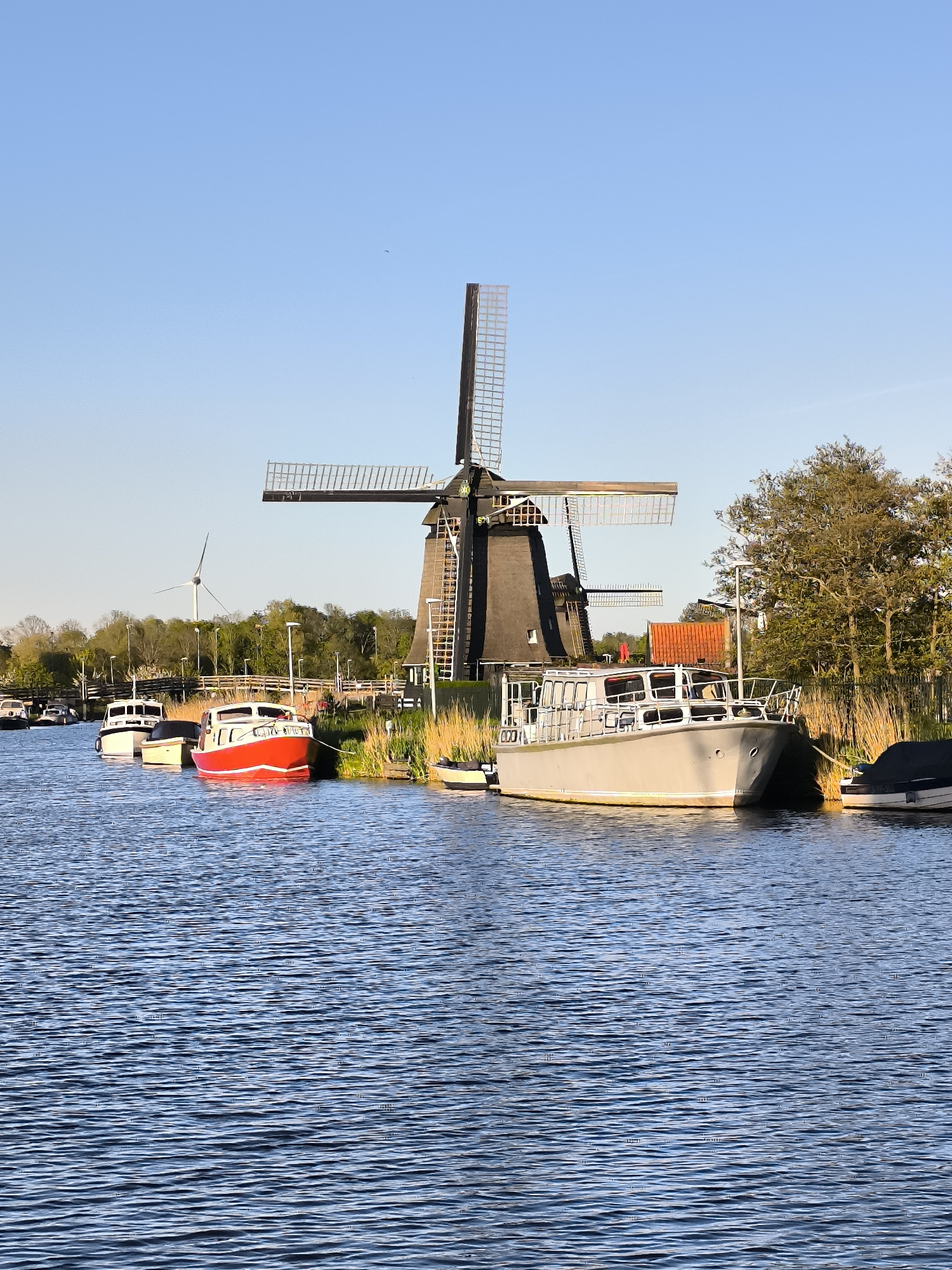 Traditional windmill photographed along Alkmaar canal under clear skies