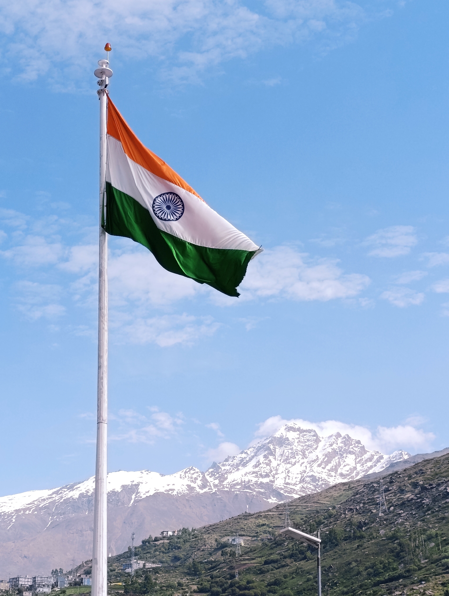 Indian flags and Himalayan peaks along a mountain road