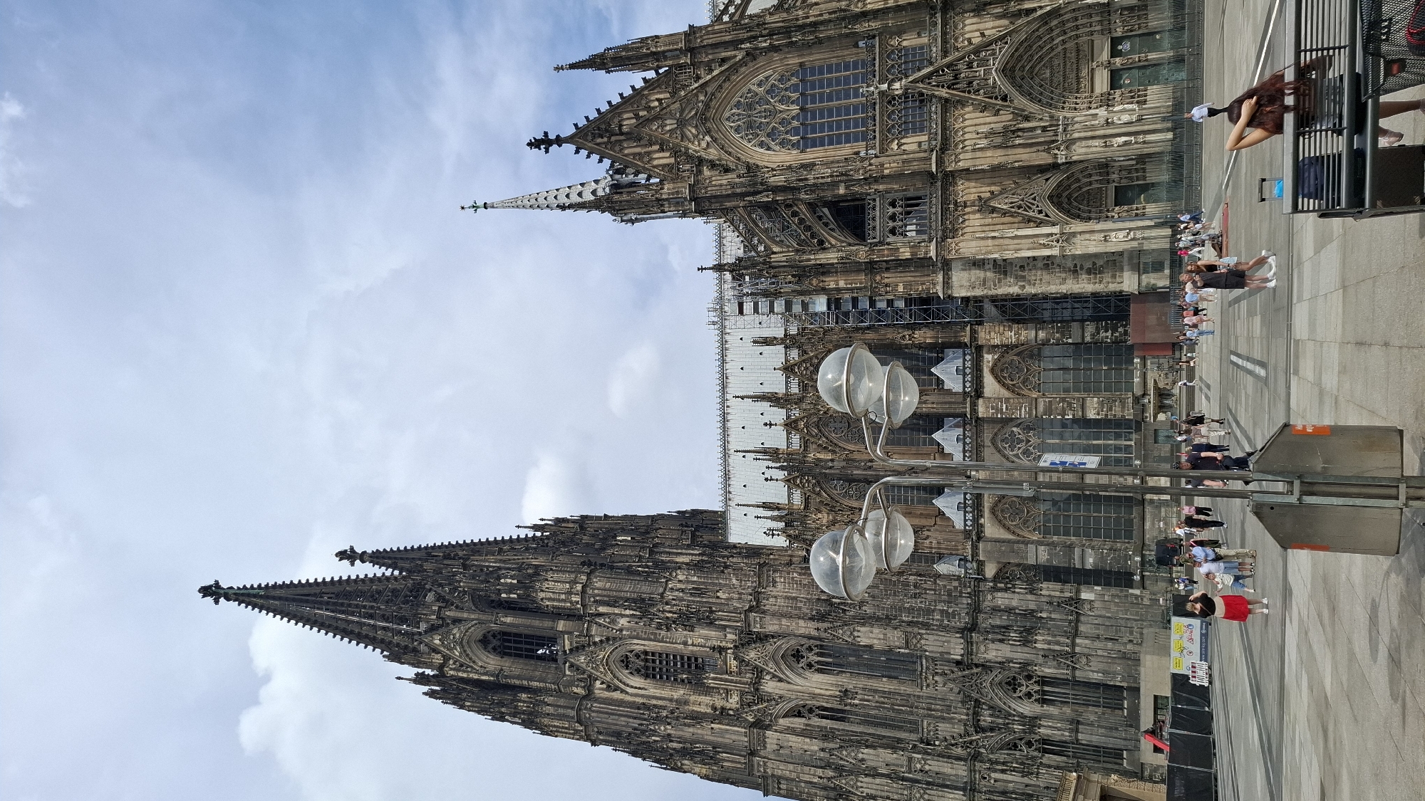 Morning at Cologne Cathedral plaza, flowers, chalk art, and Gothic spires