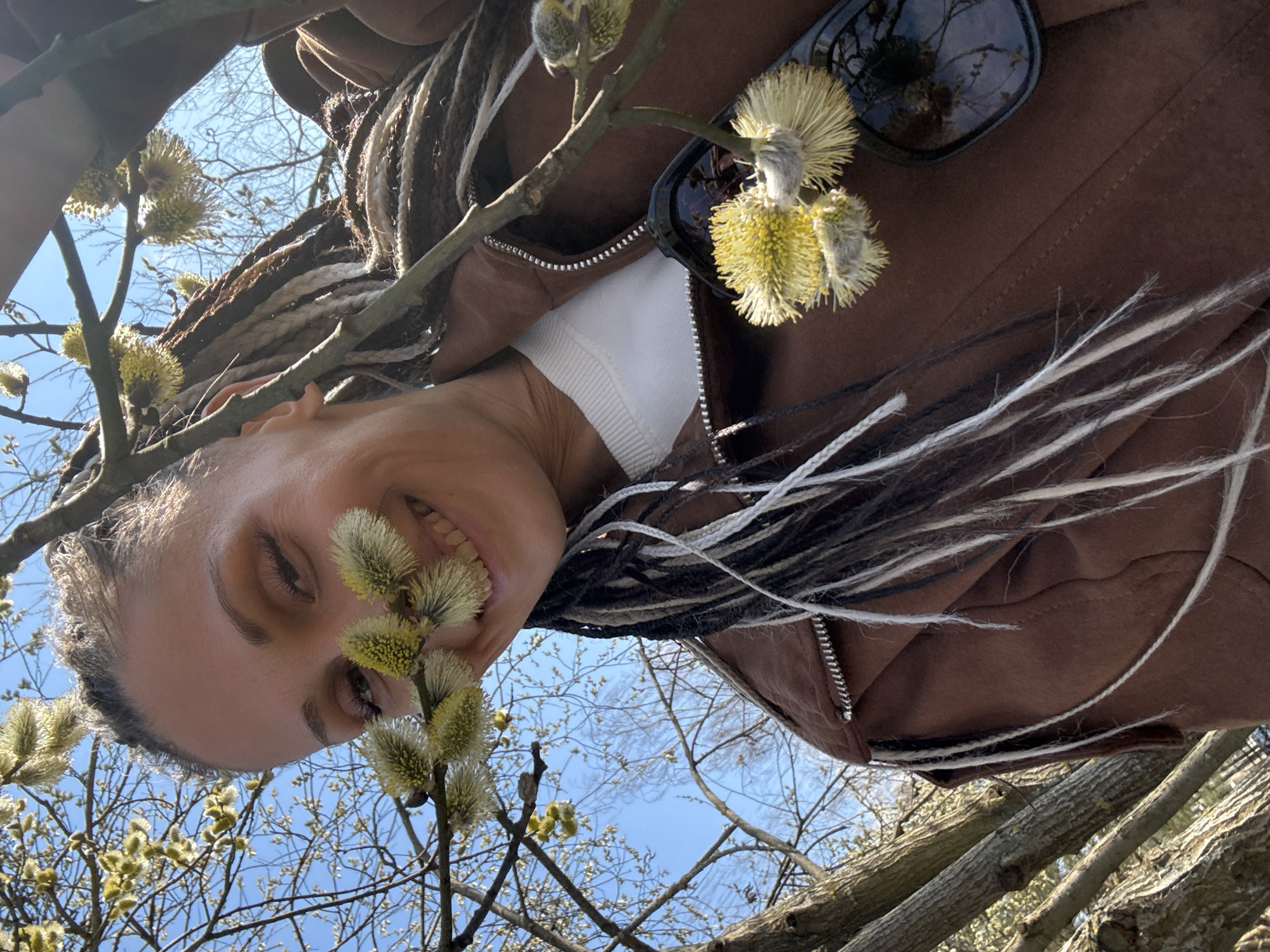 Woman photographed smiling among spring tree blossoms in Rusanovo