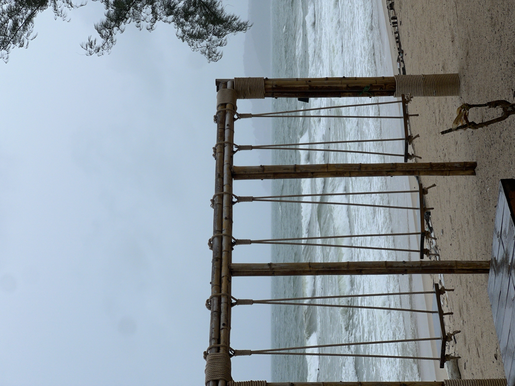 Beach scene with bamboo structure captured under overcast skies