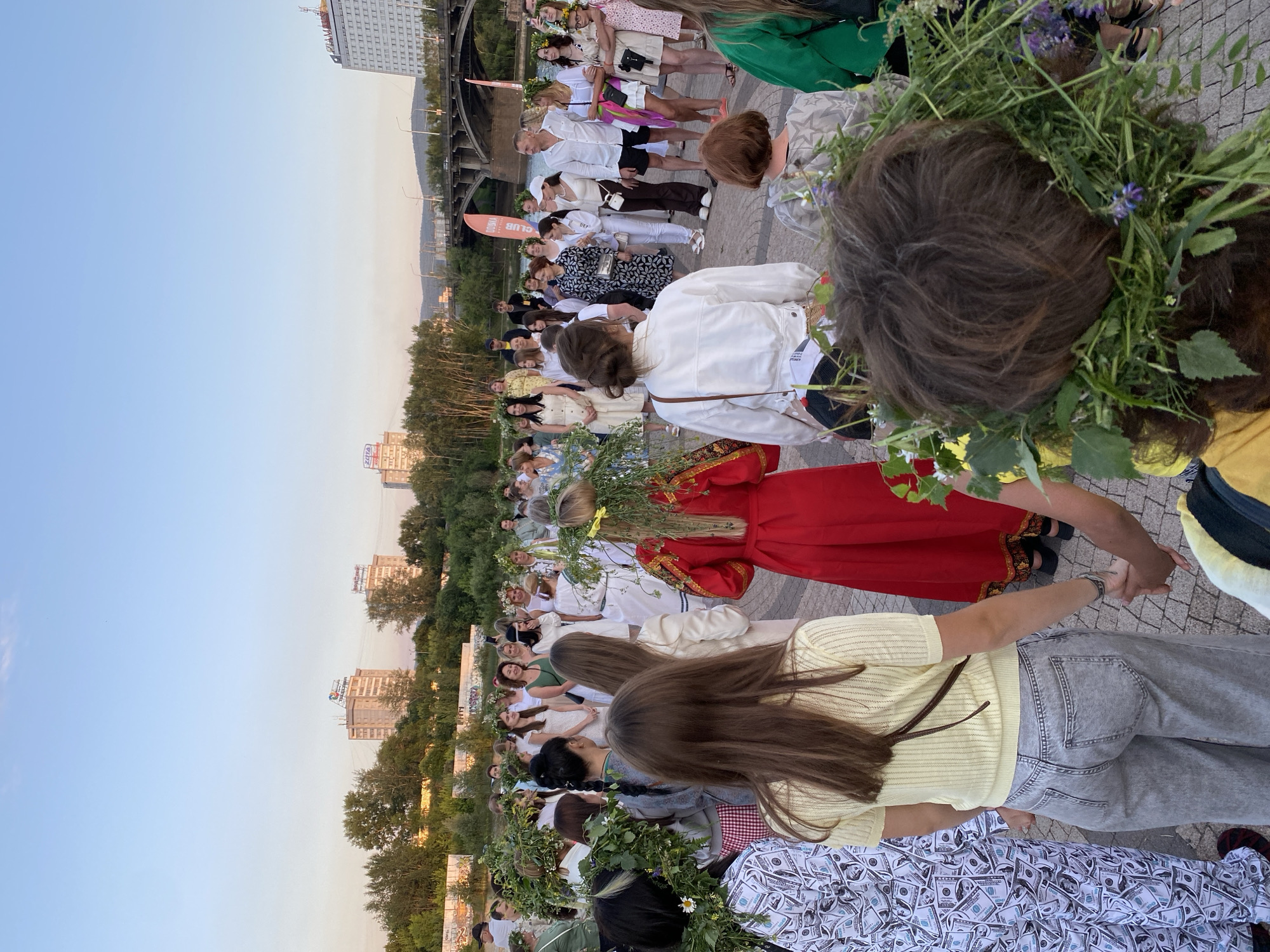 Circle dancing and flower crowns at an outdoor folk celebration