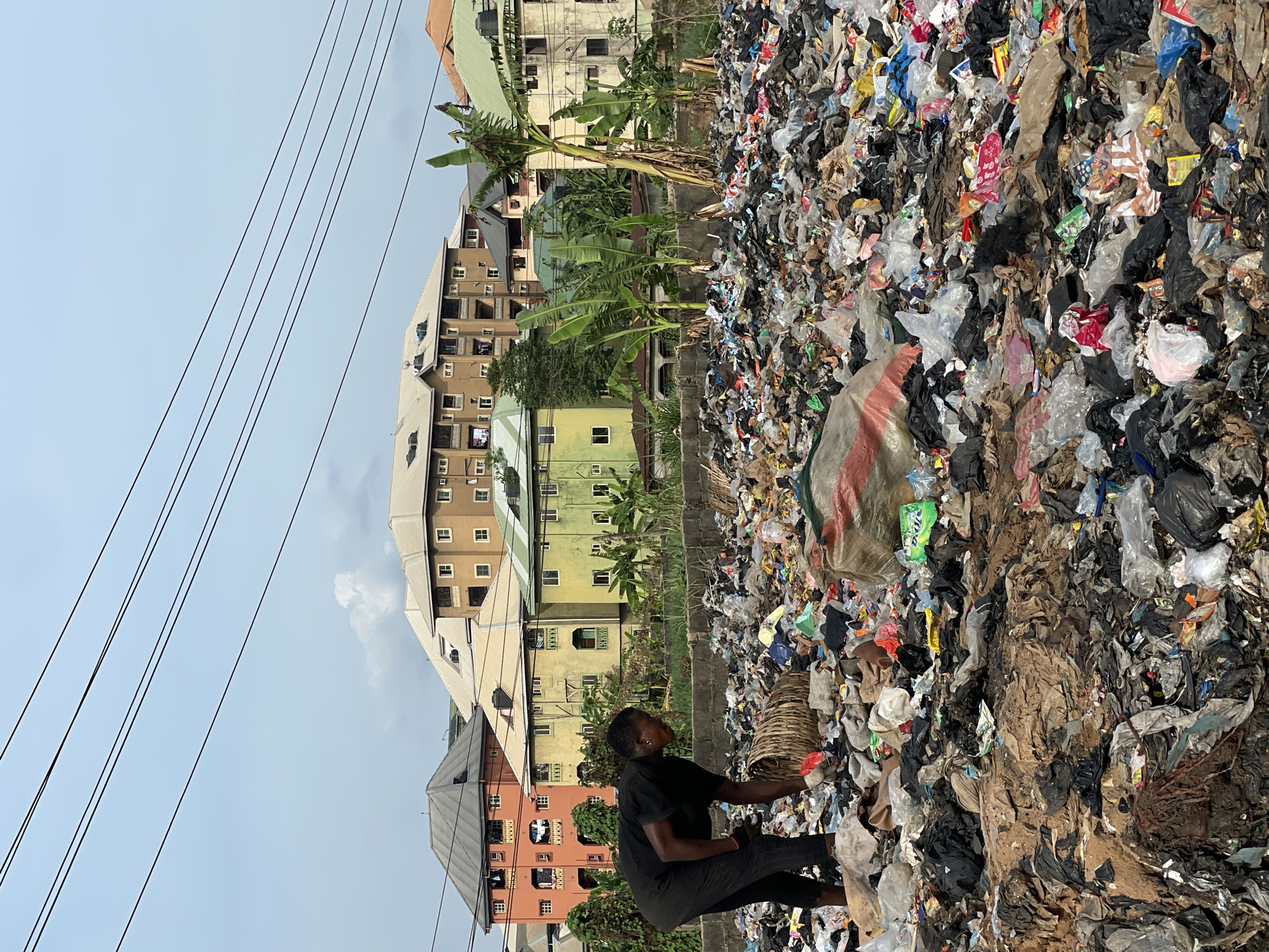 Woman sorts through trash pile in Onitsha, Nigeria