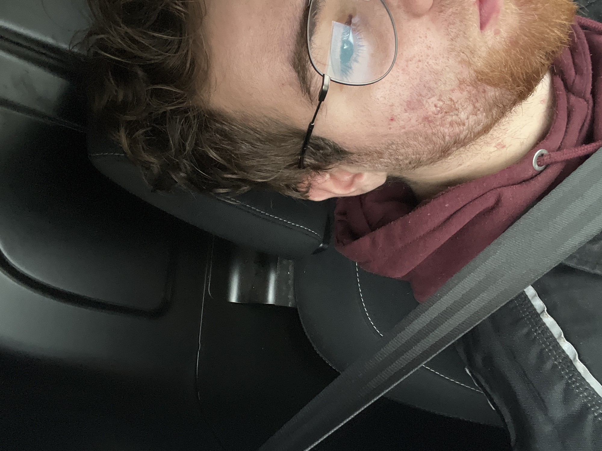 Man in glasses and maroon hoodie spotted in car