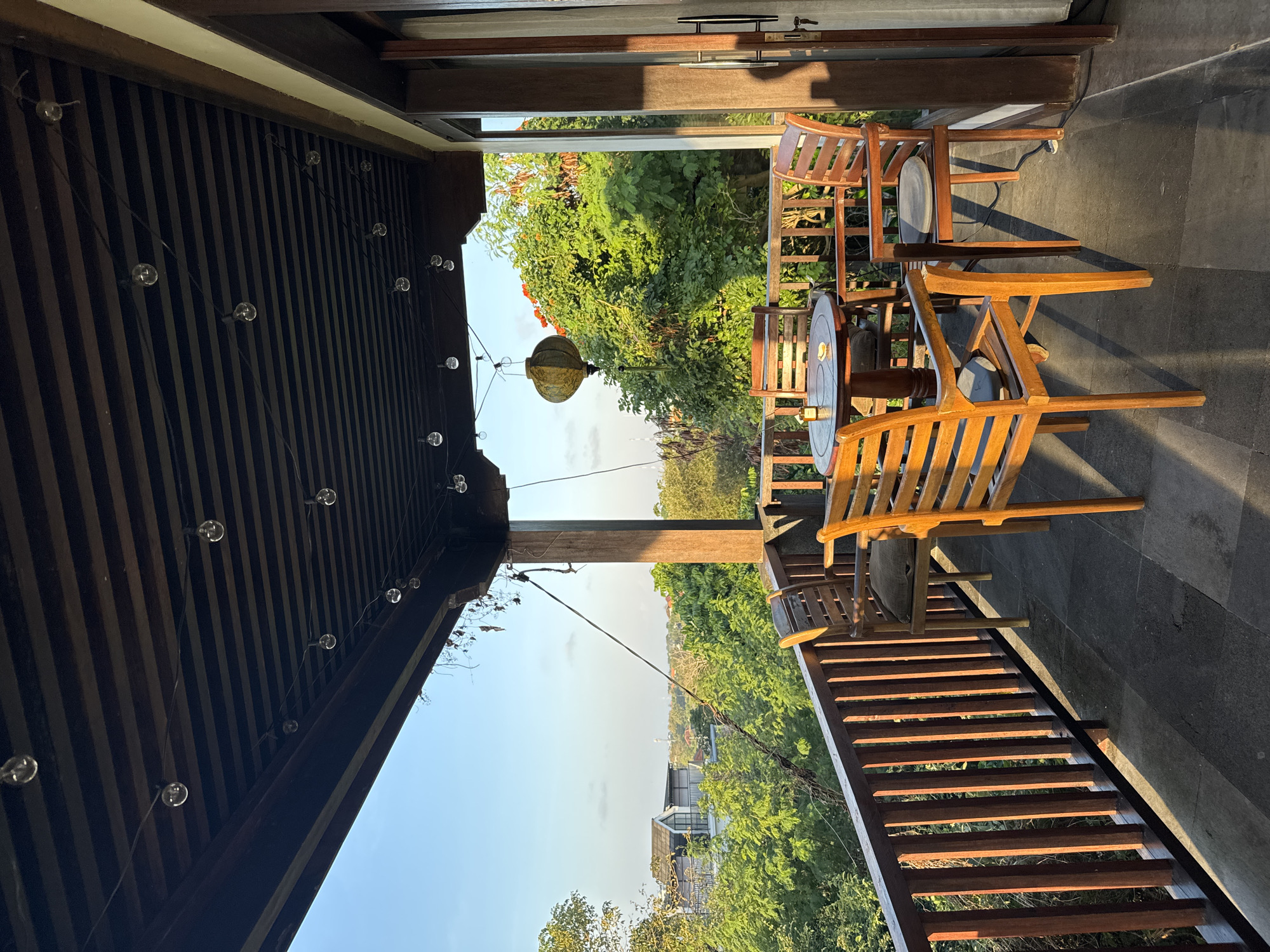 Balinese villa grounds with traditional rooftops and open-air seating