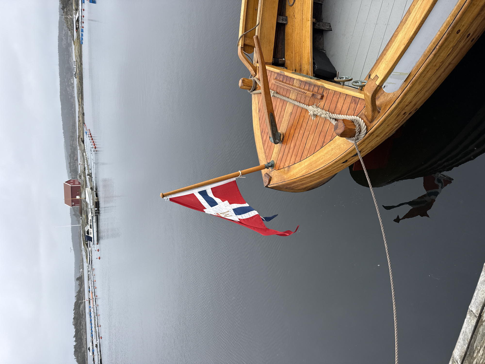 Norwegian-flagged sailboat docked in Strömstad under gray skies