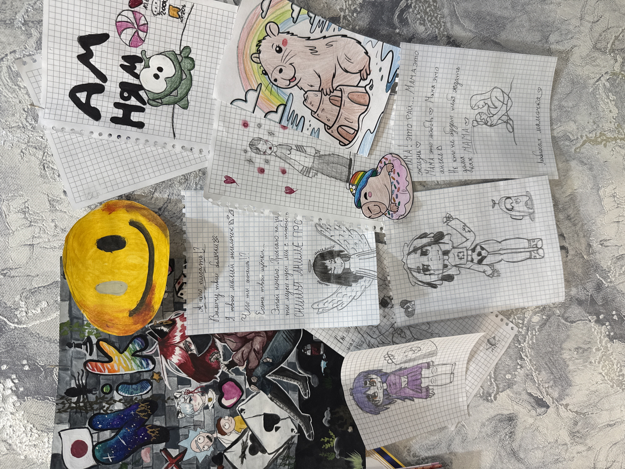 Child's artwork scattered on grey surface in Zavolzhye