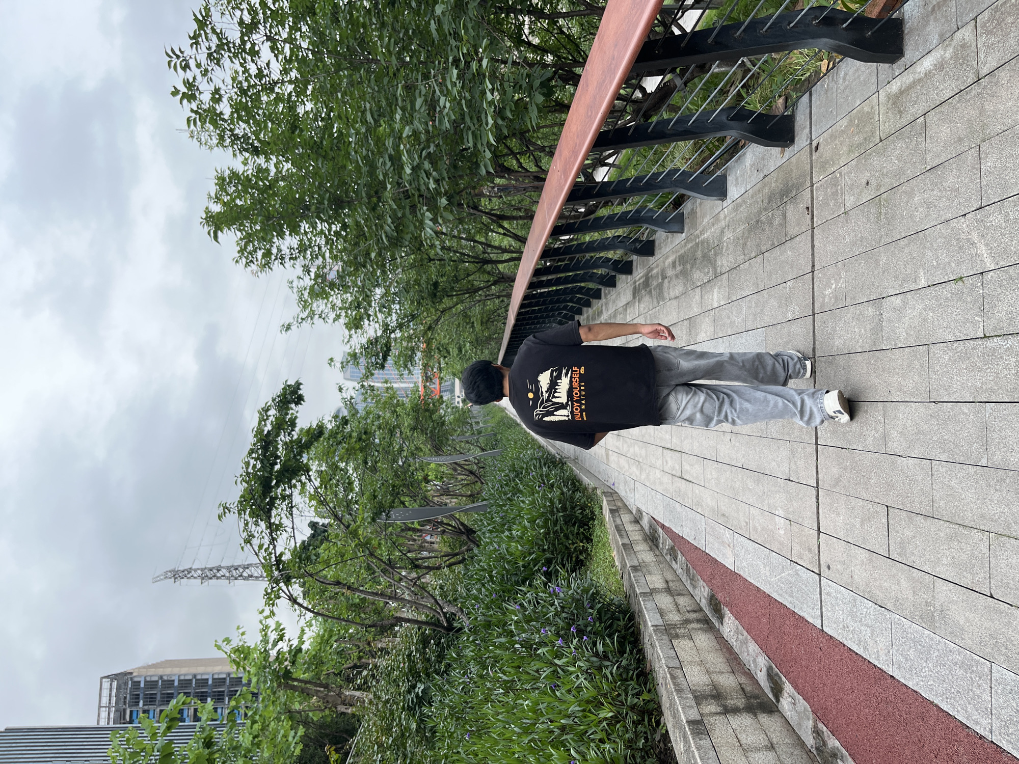 Man walks tree-lined pathway in Jiangbeicheng Subdistrict