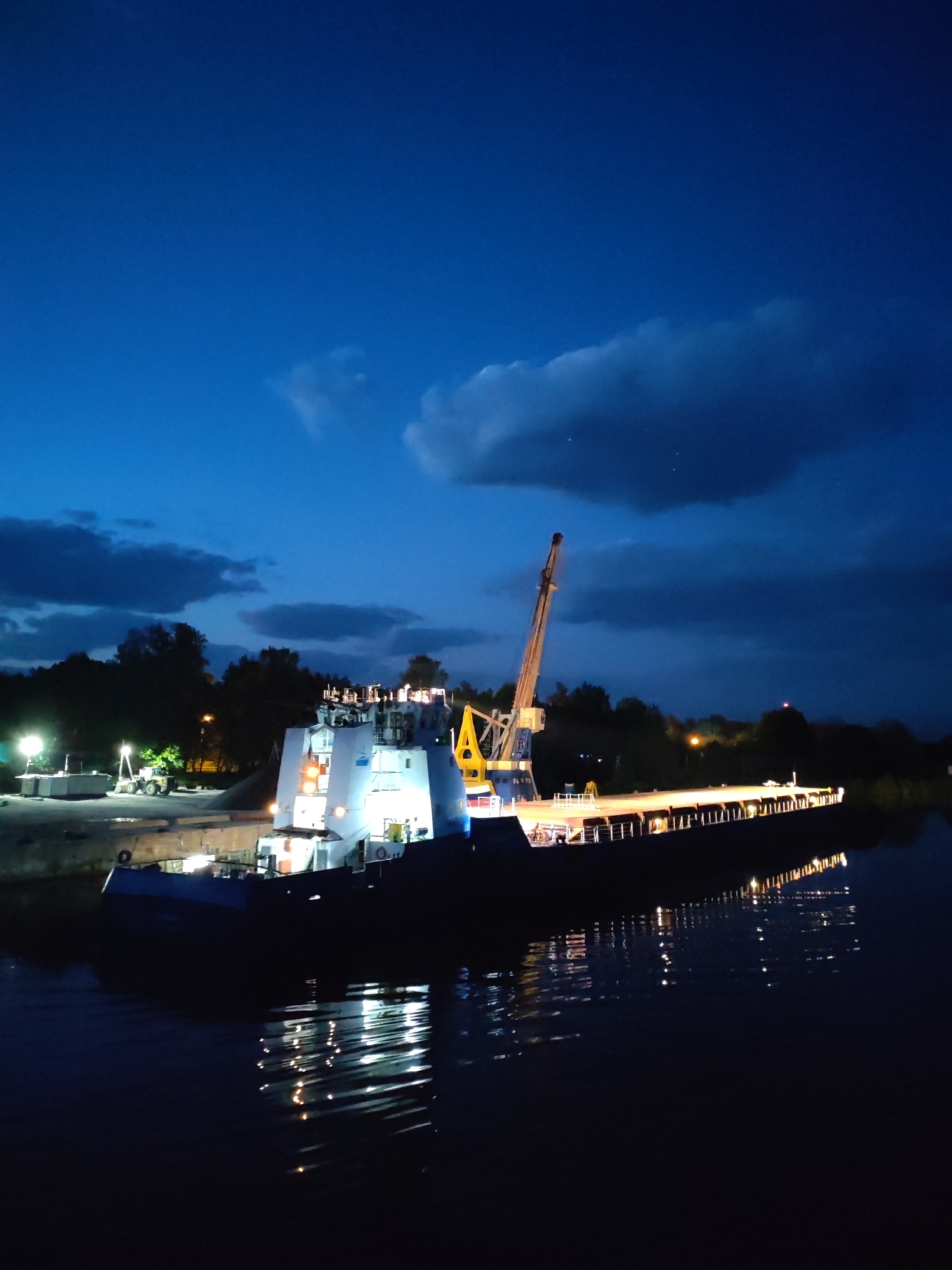 Barge with crane moored at Zaprudnya dock during night
