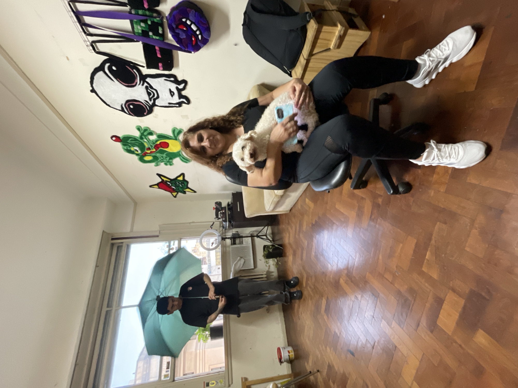 Indoor scene captured with woman, dog, and umbrella-holding man