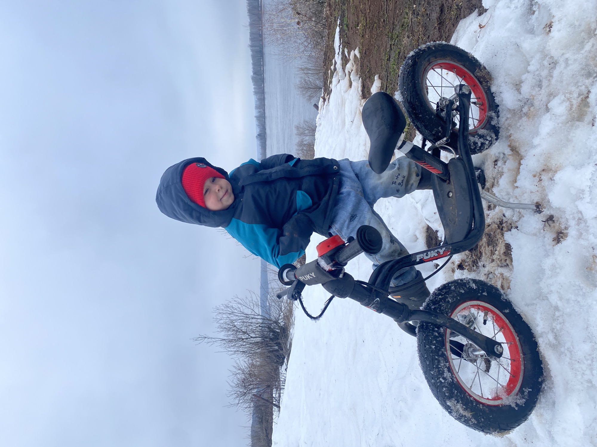 Child with balance bike spotted in snow in Ольховка