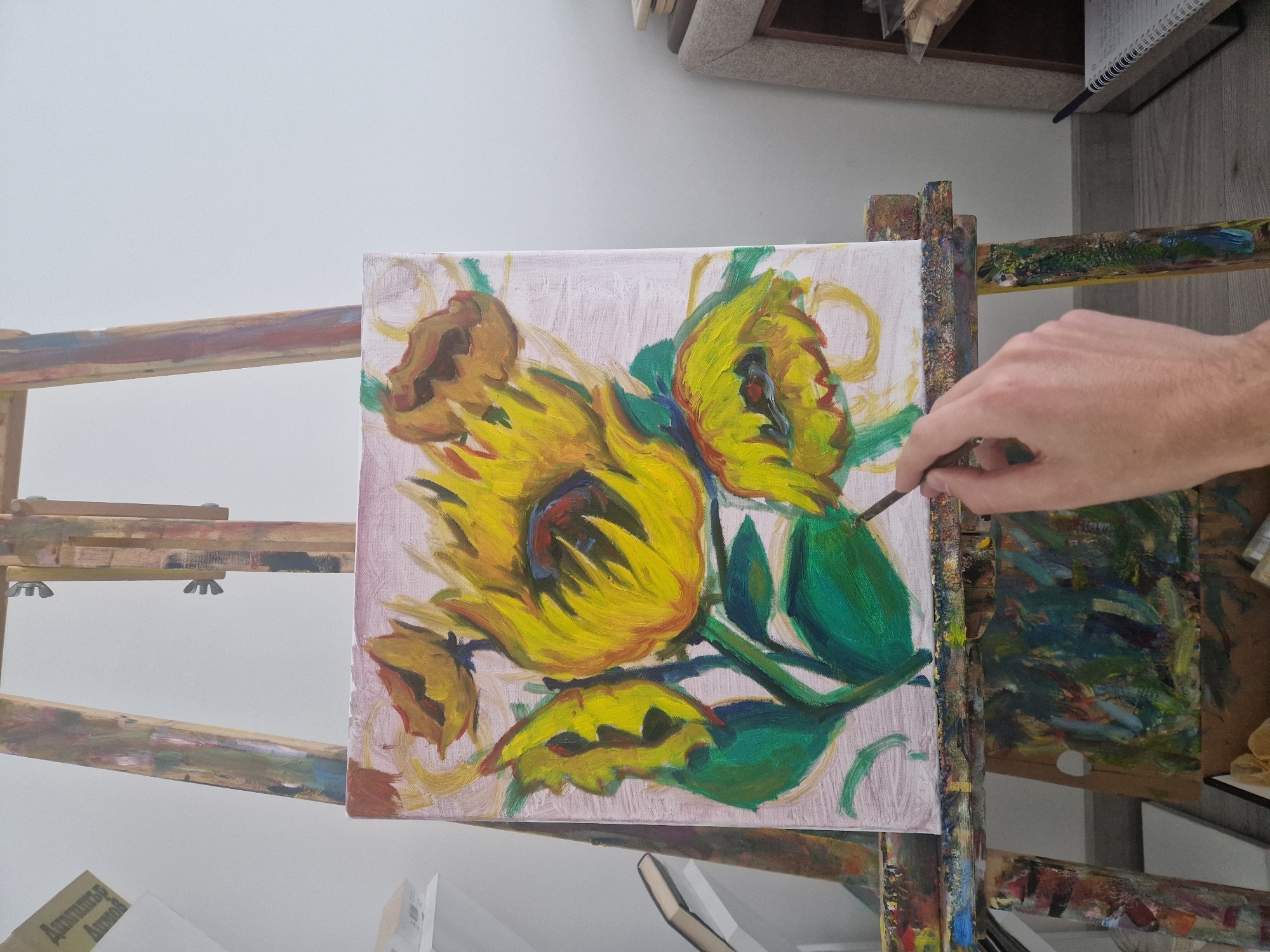 Artist paints sunflower canvas during morning session