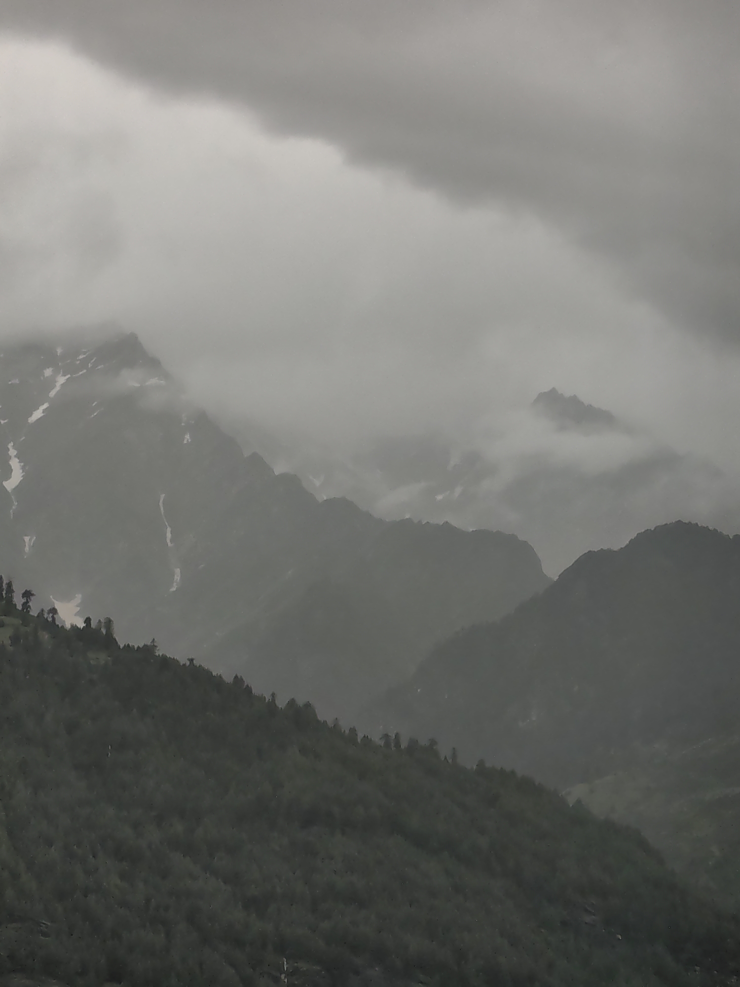 Vashisht village and its misty Himalayan surroundings on an overcast day
